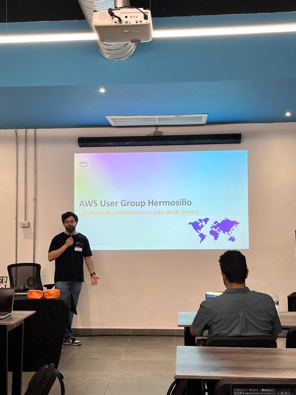 Presentador junto a la diapositiva "AWS User Group Hermosillo: Construyendo comunidad en la nube desde Sonora"